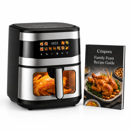 A black and stainless steel air fryer with a digital control panel and a transparent window showing roasted chicken inside, pictured next to a printed cookbook titled 'Crispora Family Feast Recipe Guide' on a clean white background.
